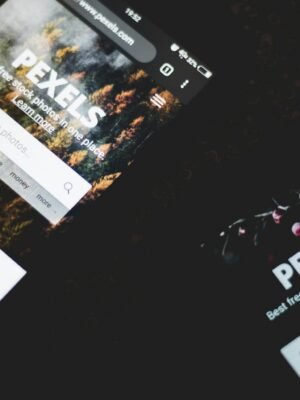Close-up of smartphones displaying Pexels stock photo website, showcasing modern technology.